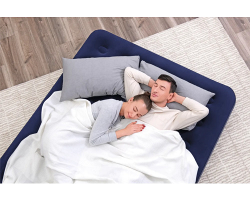 Luftmatratze mit zwei Personen unter einer Decke und zwei Kissen