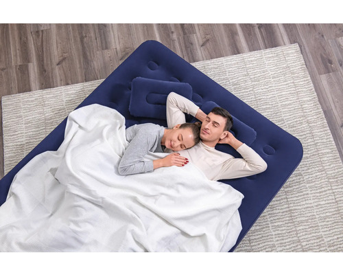 Paar schläft auf einer blauen Luftmatratze mit Kopfkissen und weißer Decke