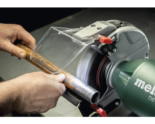 Person schleift Metallrohr mit Doppelschleifer. Metabo Logo.