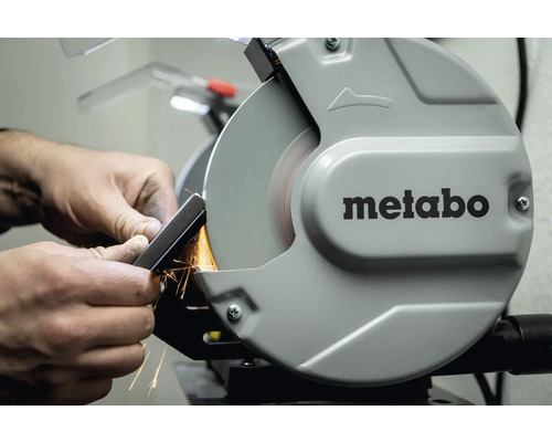 Mann schleift Metallstück an Doppelschleifer der Marke Metabo
