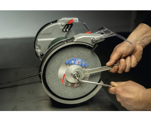 Doppelschleifer mit Schleifscheibe wird mit Schraubenschlüsseln eingestellt