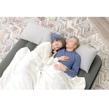 Ein Paar schläft auf einer Luftmatratze mit Kissen und Decke