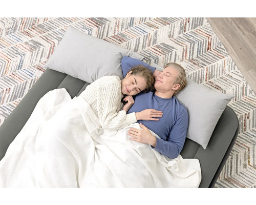 Ein Paar schläft auf einer Luftmatratze mit Kissen und Decke