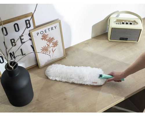 Staubwedel in Verwendung auf einer Tischoberfläche