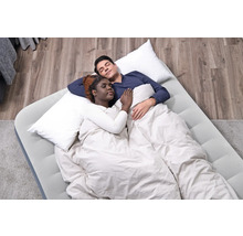 Ein Paar schläft auf einer Luftmatratze mit Kissen und Decke