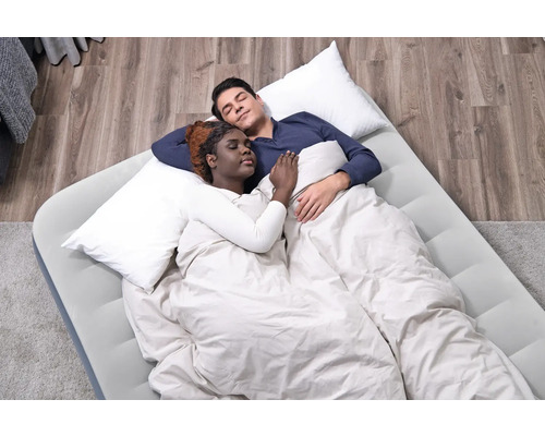 Ein Paar schläft auf einer Luftmatratze mit Kissen und Decke