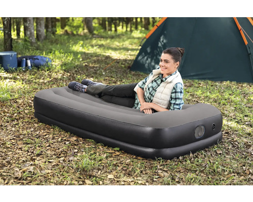 Frau liegt auf Luftmatratze beim Camping