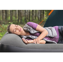 Frau ruht auf einer Luftmatratze beim Camping