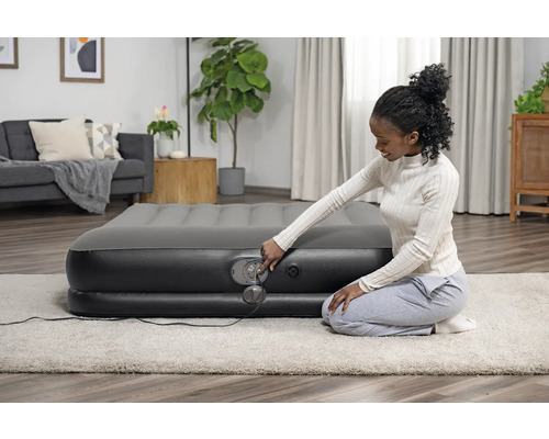 Aufblasbare Gästematratze mit integrierter Pumpe in einem Wohnzimmer.