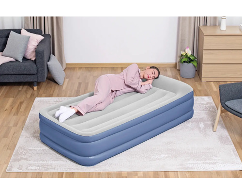 Frau schläft auf einer blauen Luftmatratze im Wohnzimmer