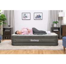 Frau liegt auf einer grauen Bestway Luftmatratze im Zimmer.