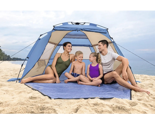 Familie entspannt in einem Strandzelt am Meer.