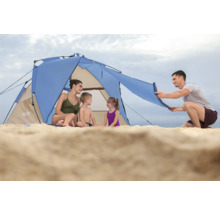 Familie sitzt im Strandzelt am Sandstrand