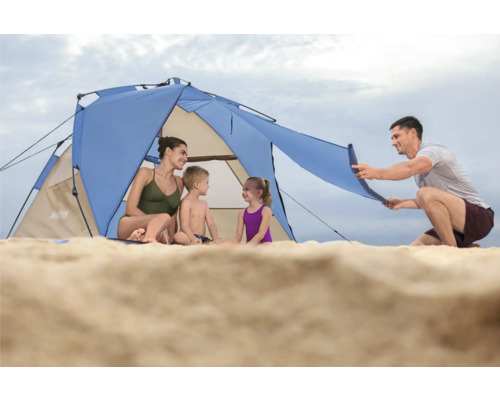 Familie sitzt im Strandzelt am Sandstrand