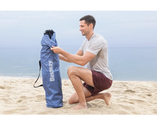Mann öffnet eine Tragetasche für einen Strandsitz der Marke Bestway am Strand