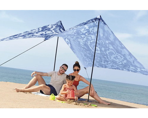 Familie unter einem Sonnensegel am Strand