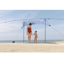 Strandszene mit Mutter und Kind unter einem Sonnensegel.