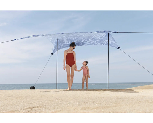 Strandszene mit Mutter und Kind unter einem Sonnensegel.