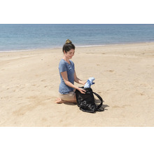 Frau packt eine Tasche am Strand