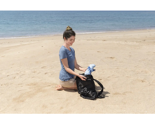Frau packt eine Tasche am Strand