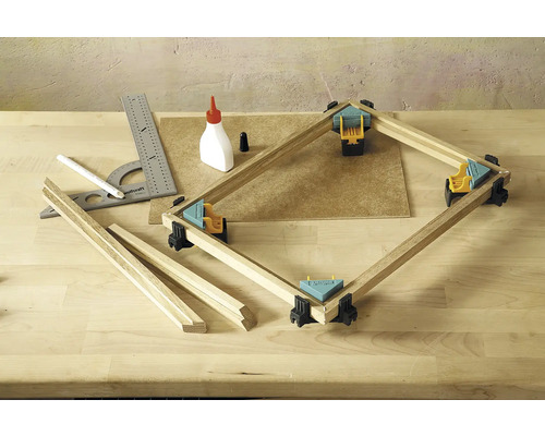 Werkbank mit Gehrungsklammern, Holzleisten, Winkel, Bleistift und Leimflasche für Holzarbeiten