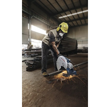 Ein Arbeiter benutzt eine Metalltrennsäge in einer Werkshalle.