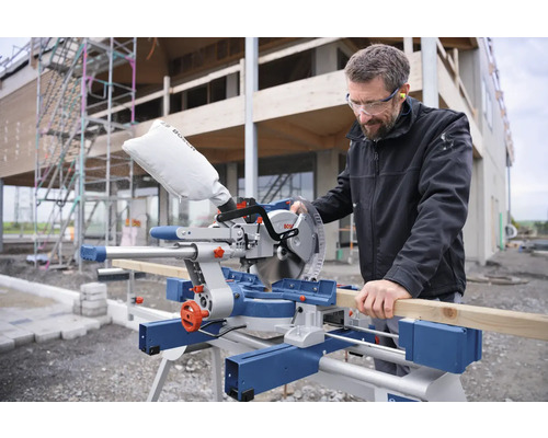 Mann schneidet Holz mit einer Kapp- und Gehrungssäge von Bosch auf einer Baustelle