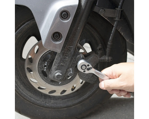 Eine Person benutzt eine Knarre am Motorrad.