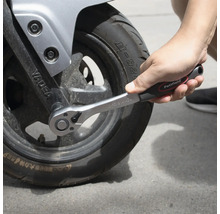Ratschenschlüssel beim Anziehen eines Motorradreifens.