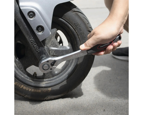 Ratschenschlüssel beim Anziehen eines Motorradreifens.