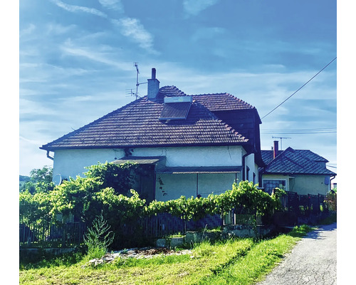 Haus mit Ziegeldach, Solarkollektor und Antenne