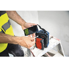 Person lädt ein Mobiltelefon an einem Bosch Baustellenradio auf.