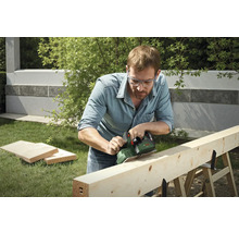 Mann hobelt Holzbalken im Garten mit Elektrohobel der Marke Bosch