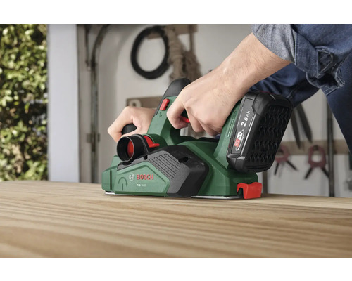 Person hobelt Holzbrett mit einem Bosch Akku-Hobel
