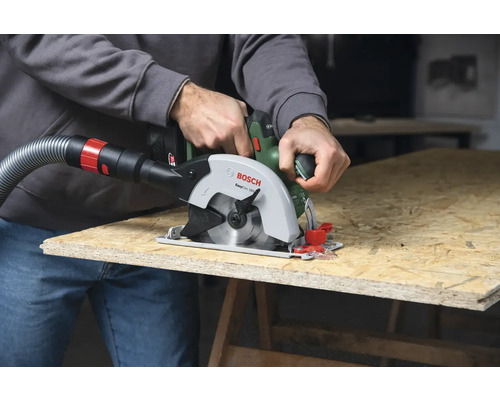 Mann sägt Holzplatte mit einer Bosch Handkreissäge