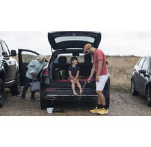 Szene mit Familie, die sich nach einem Ausflug im Freien die Füße mit einem Gartenschlauch reinigt.
