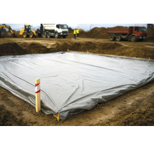 Abdeckplane auf einer Baustelle mit Baugeräten im Hintergrund
