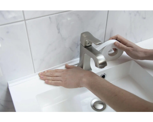 Anbringen eines weißen Dichtungsbands an einem Waschbecken im Badezimmer.