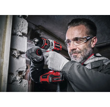 Mann bohrt mit einem Einhell Akku-Bohrschrauber in eine Mauer.