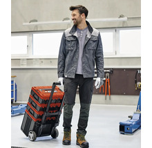 Handwerker mit Werkzeugkoffer auf Rädern in einer Werkstatt