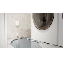 Wassermelder im Einsatz neben einer Waschmaschine, Wasser auf dem Boden