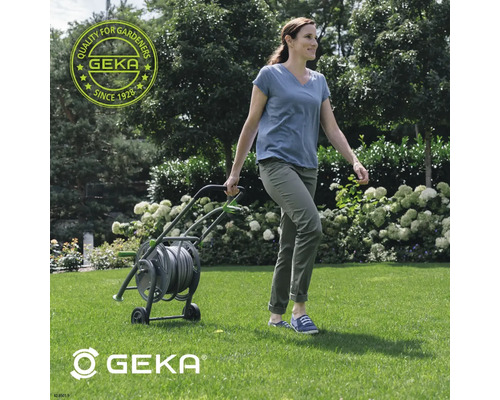 Frau zieht einen Gartenschlauchwagen von Geka über den Rasen