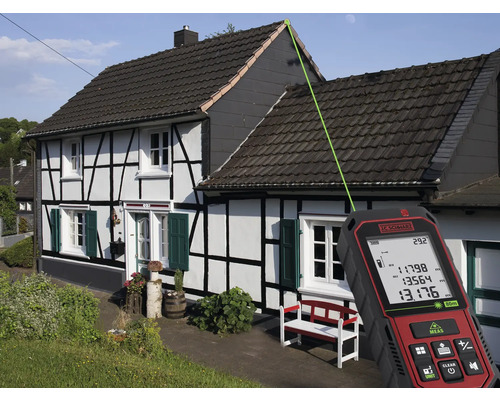 Ein Laser-Entfernungsmesser misst die Dachhöhe eines Hauses