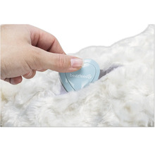 Hand, die ein herzförmiges Behältnis mit dem Beeztees Logo auf einem Fell platziert.