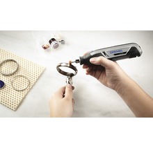Dremel Logo. Eine Person poliert einen Armreif mit einem Dremel Multifunktionswerkzeug.