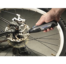 Dremel Logo. Eine Person verwendet ein Dremel Lite Werkzeug an einer Fahrradbremsscheibe.