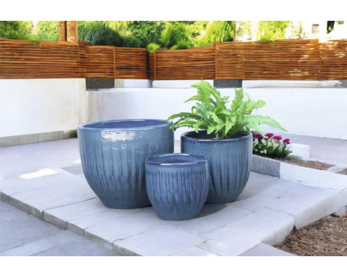Drei Pflanzgefäße in unterschiedlichen Größen auf einer Terrasse