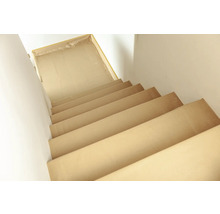 Treppe abgedeckt mit Malervlies zum Schutz während Renovierungsarbeiten.