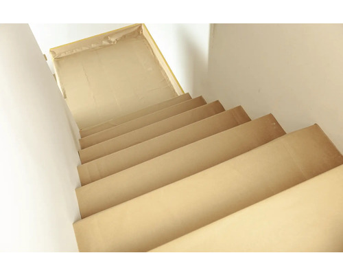 Treppe abgedeckt mit Malervlies zum Schutz während Renovierungsarbeiten.