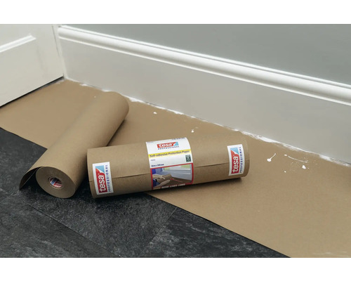 Zwei Rollen selbstklebendes Schutzpapier von Tesa liegen auf dem Boden, um Oberflächen vor Verschmutzungen zu schützen.